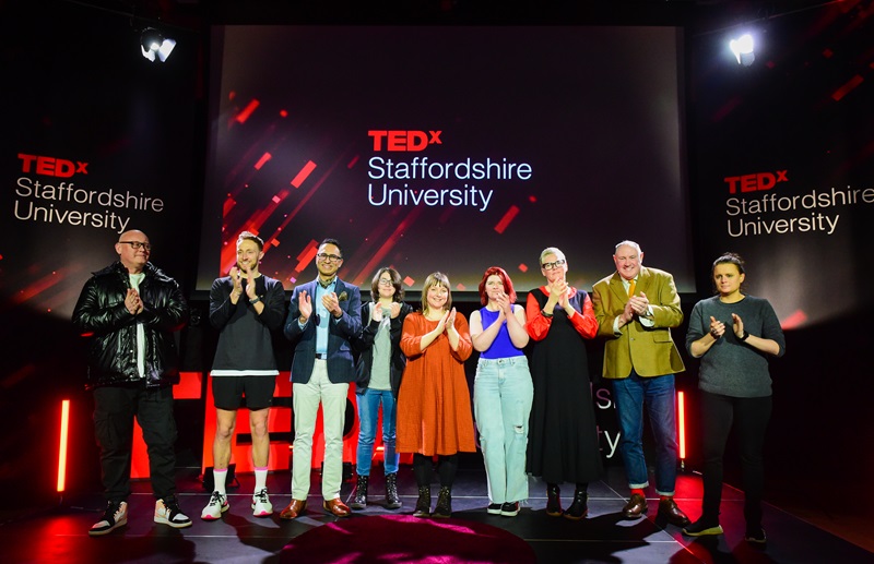 Peoplle lined up on stage in front of TEDxStaffordshireUniversity branding
