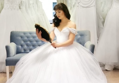 A woman in a wedding dress looking in a mirror