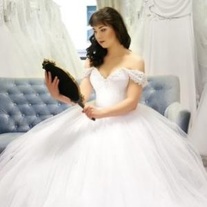 A woman in a wedding dress looking in a mirror