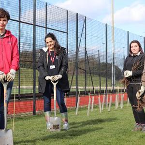 Image of Staffordshire University students alongside Dr Eleanor Atkins on campus digging to add new trees to the environment