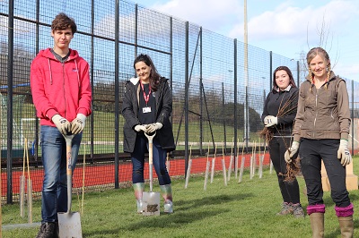 Image of Staffordshire University students alongside Dr Eleanor Atkins on campus digging to add new trees to the environment