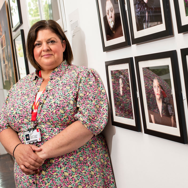 Photography student standing by their artwork