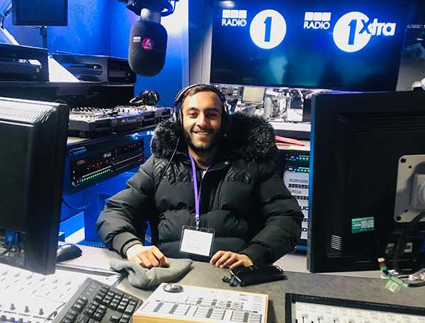 Male student sitting in the host seat at BBC Radio 1