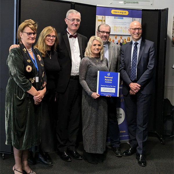 The Institute of Policing Work-Based-Education team are dressed formally and smiling, holding the award for Pastoral Team of the Year