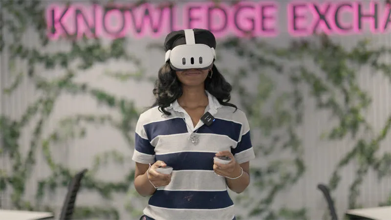 A female wearing a stripey tshirt is wearing a VR headset