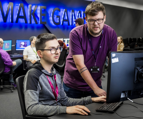 Two male students are working together in the games lab