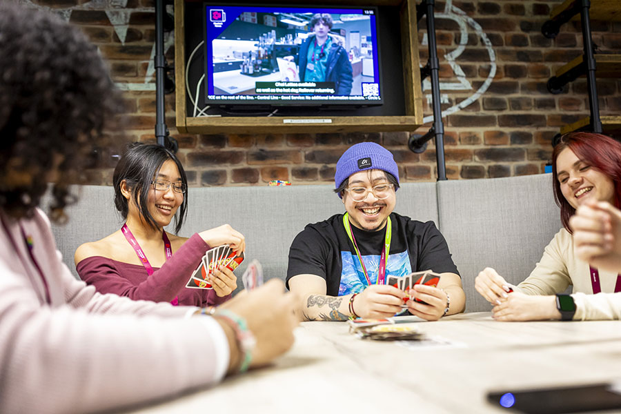 Students playing a card game at the London campus