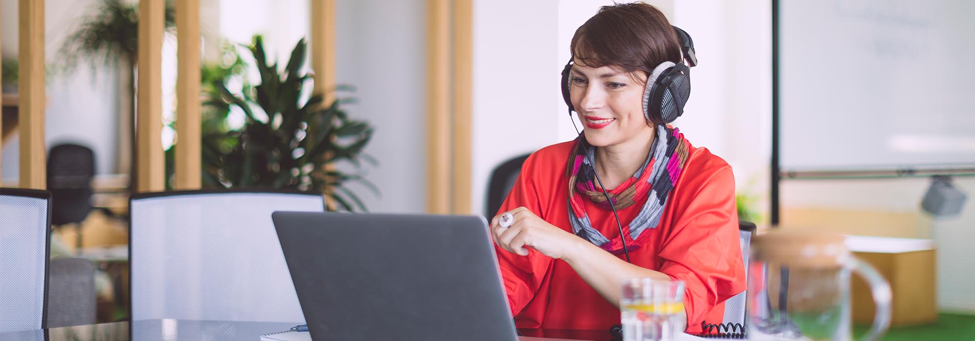 female employee at a laptop with headphones on