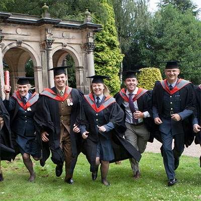 Group of HM forces graduates at the Staffordshire University graduation ceremony in a garden
