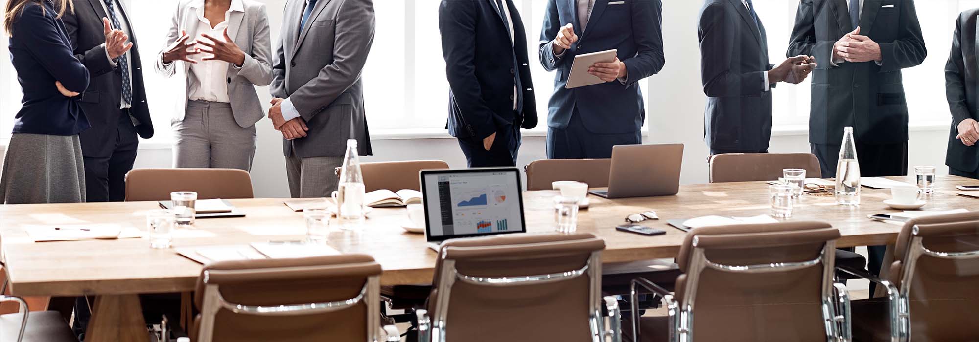 adults standing around a meeting room table