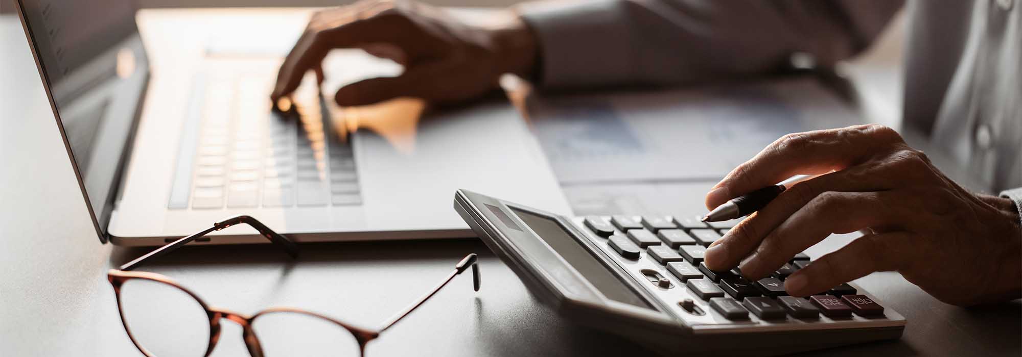 student with calculator and laptop