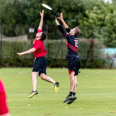 Number 13 for Staffs jumps into the air to catch the frisbee against a missed interception by Keele