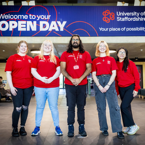 A group of student ambassadors wearing red tshirts are standing in the Catalyst together for a photo on Open Day