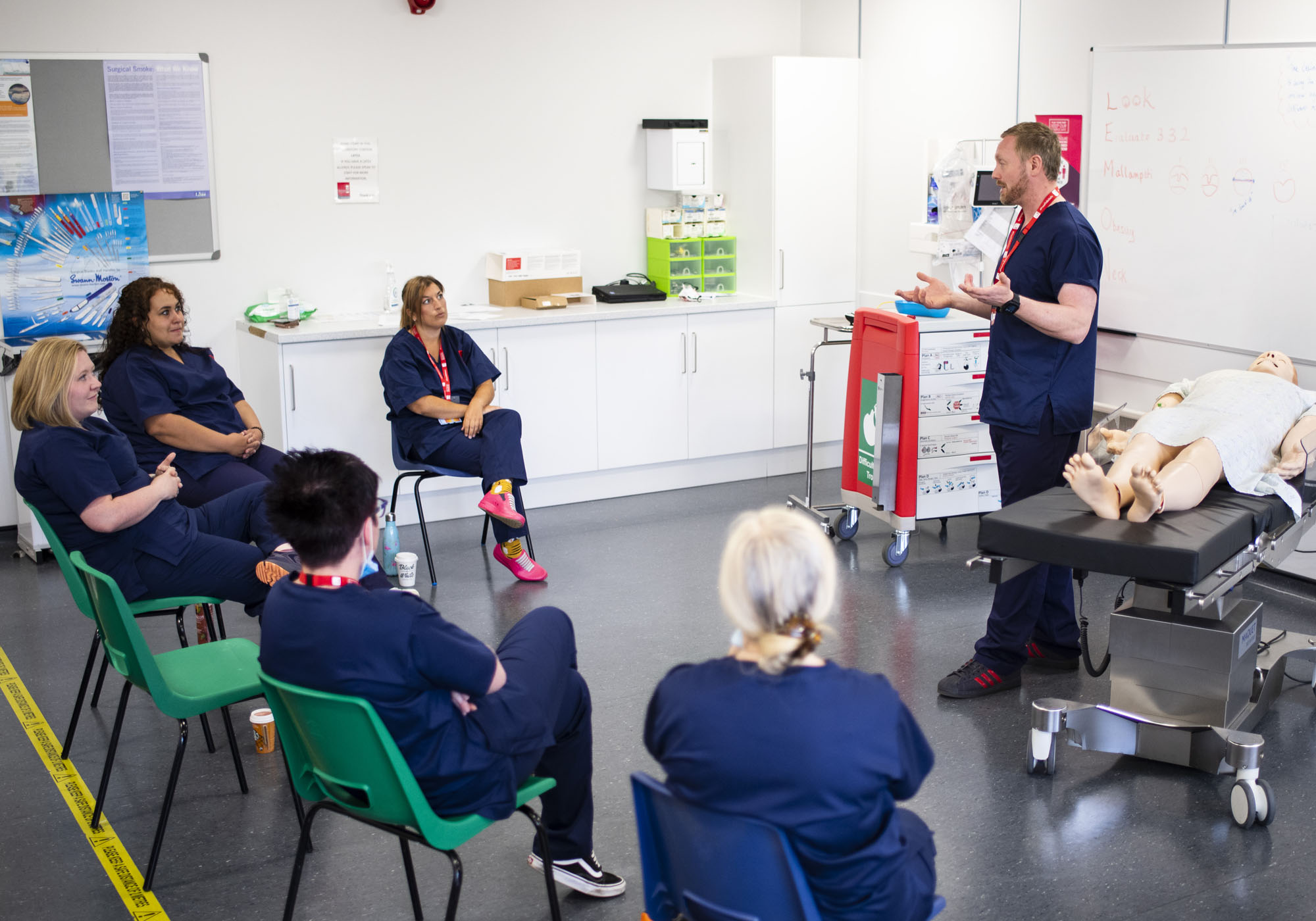 Student healthcare students are in the clinical room listening to a lecturer