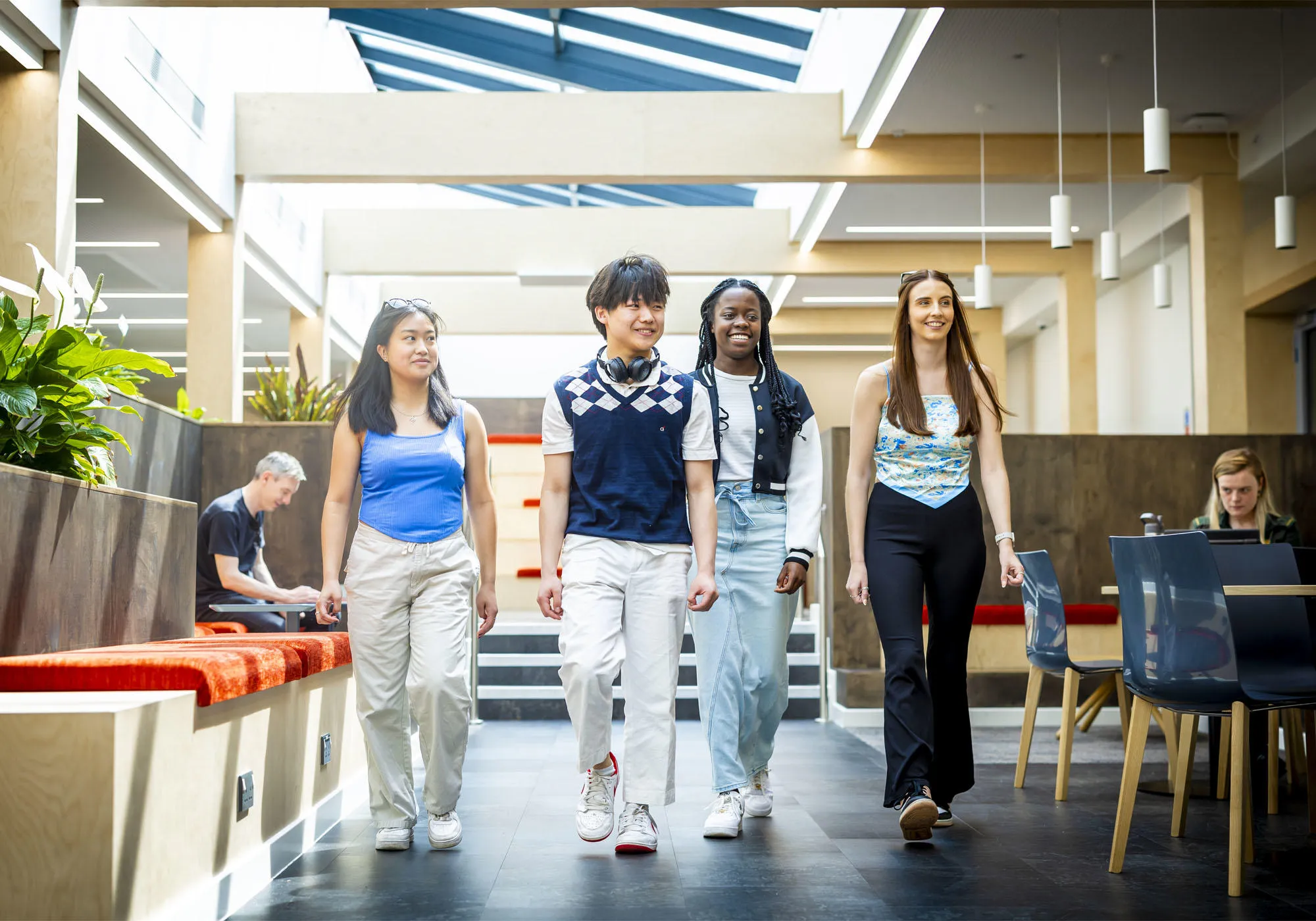 A group of students are walking through the Stafford social space