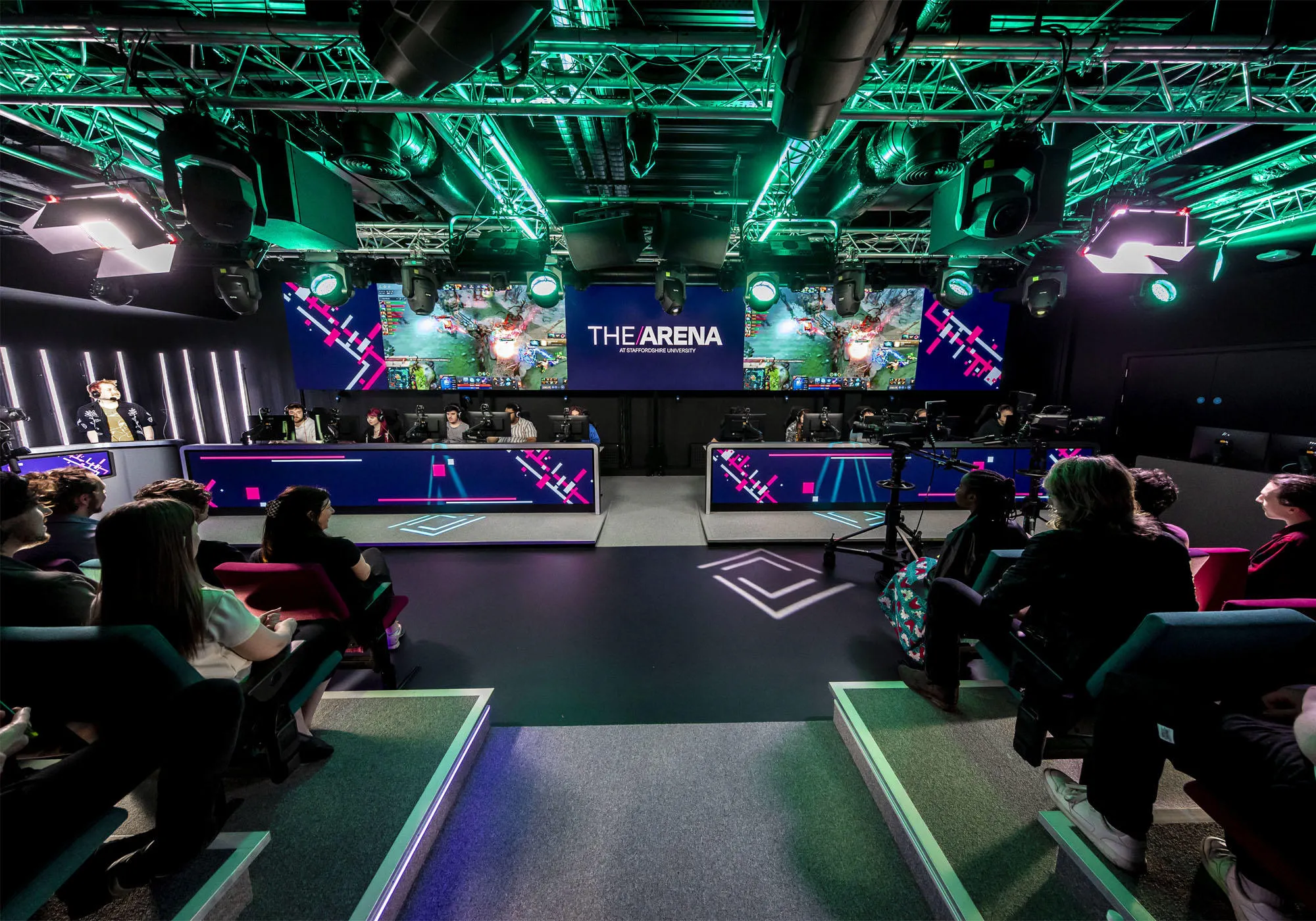 People are sitting in the esports arena watching a live stream