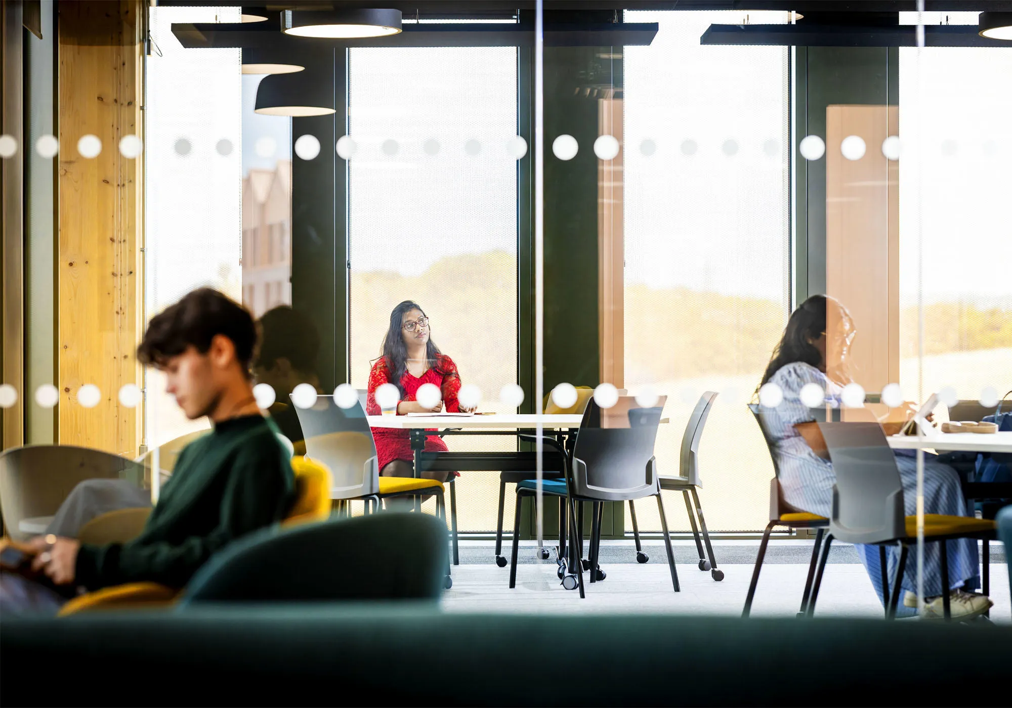 Students are in the modern hub reading, relaxing and working on their laptops