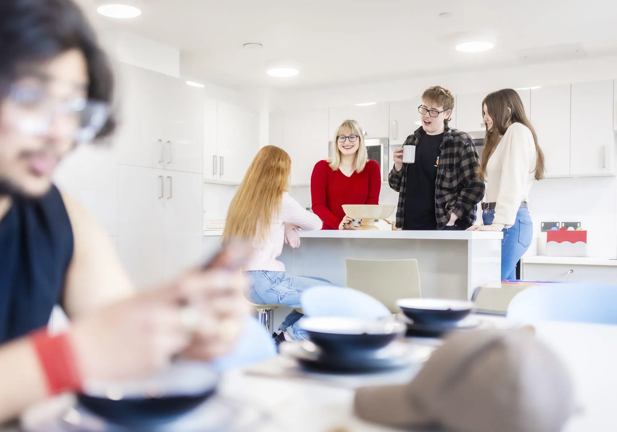 A group of students are socialising in the shared kitchen