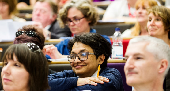 female student smiles as she leans on a desk in our Science Centre lecture theatre