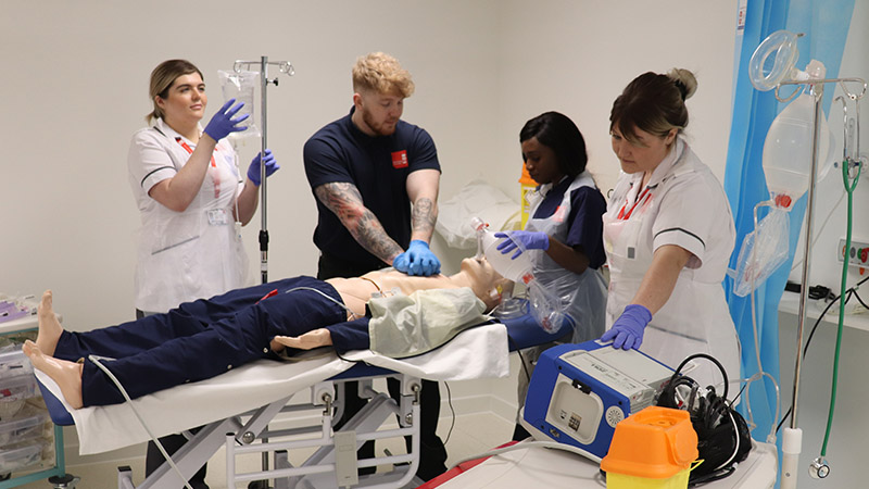 Healthcare students work on a mock patient in the simulation suite at the Centre for Health Innovation
