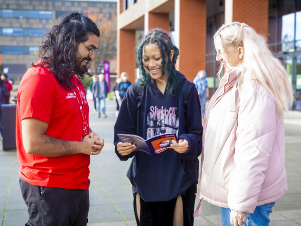 Visiting students on an open day are talking with a student ambassador outside the Catalyst